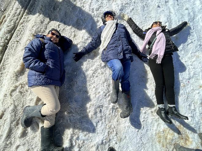 A group of people lying on snow

Description automatically generated