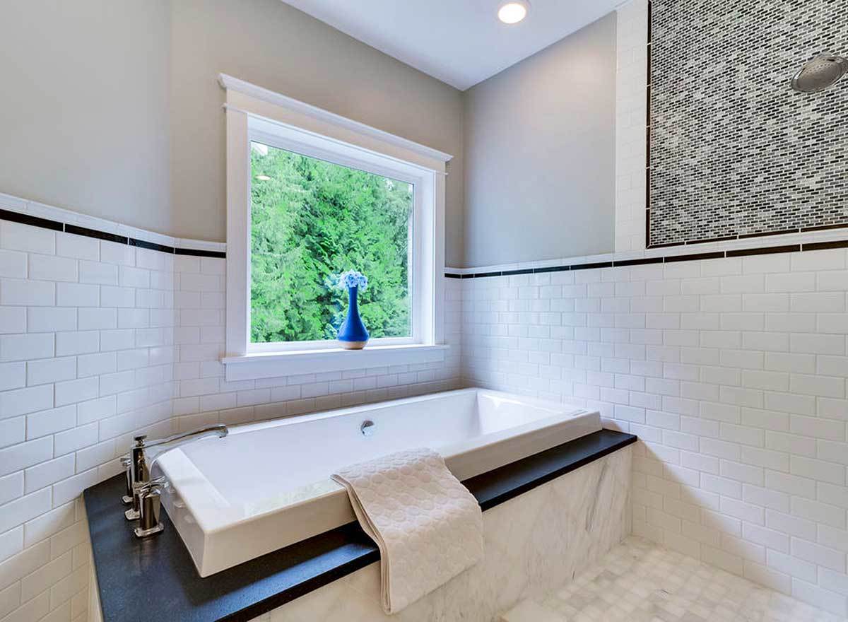 A deep soaking tub fixed under the picture window completes the primary bathroom.
