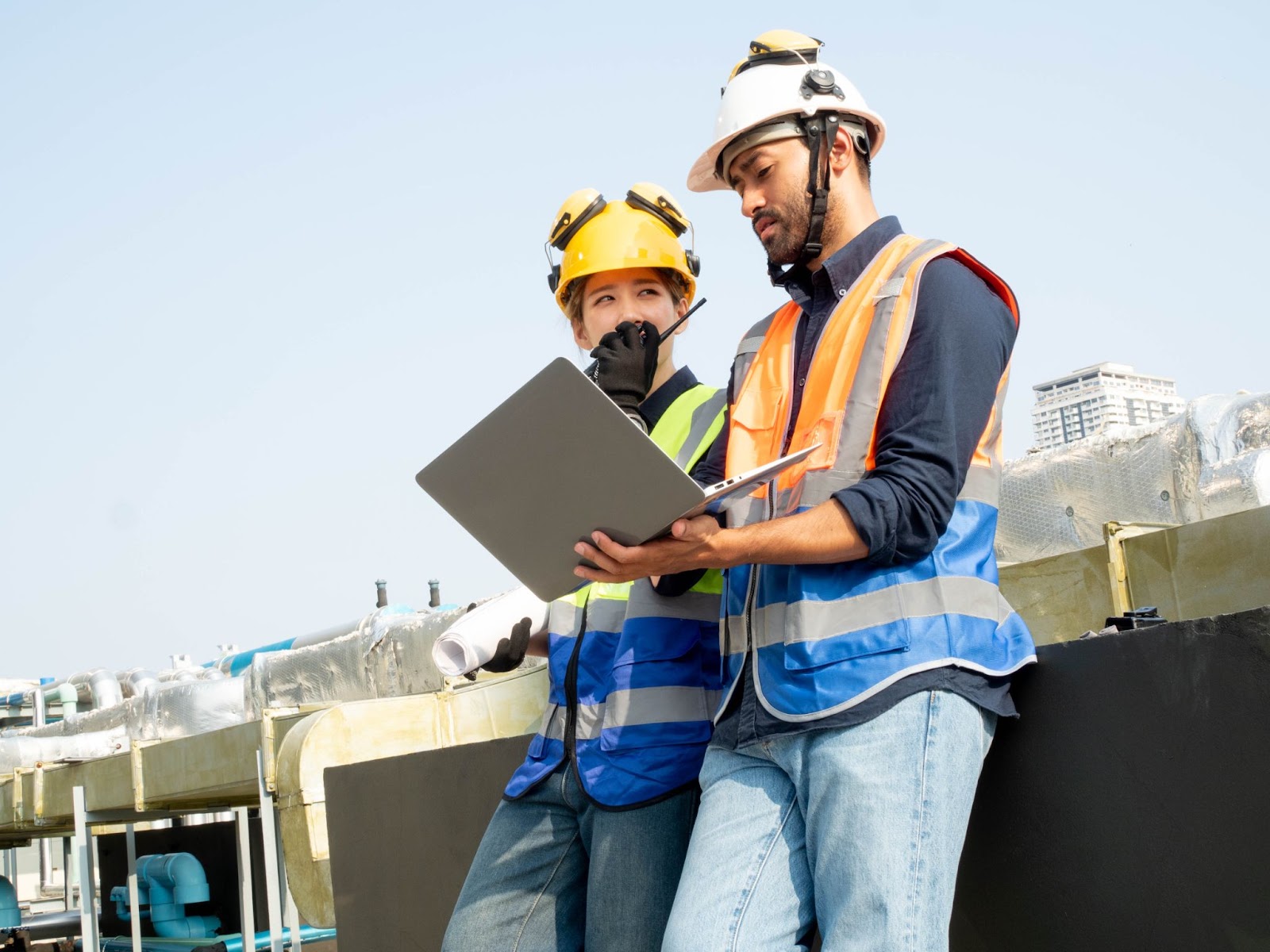 Two construction workers using a laptop. 