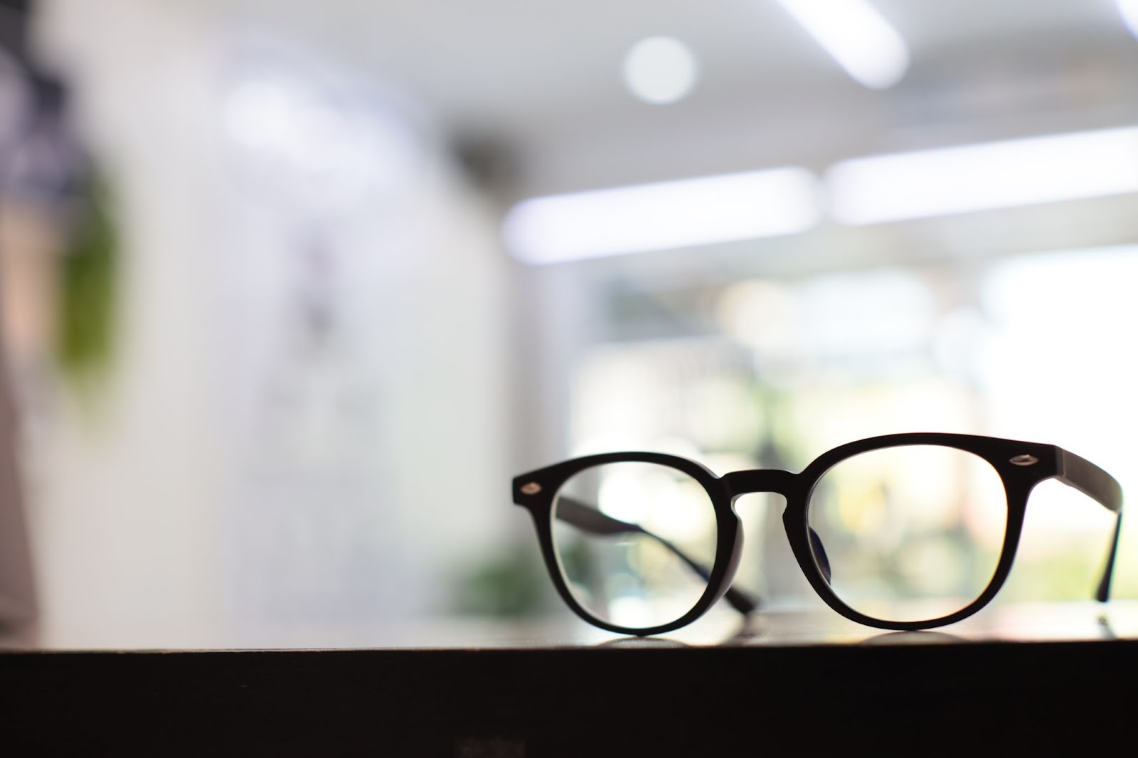 a pair of progressive lenses on a wood counter top with a blurred background.