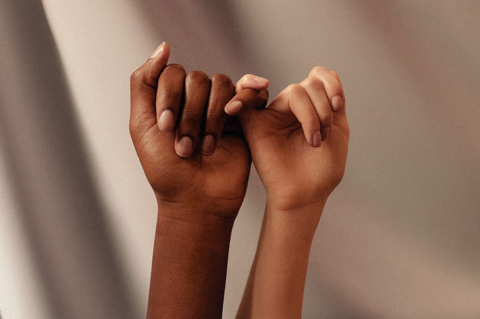 Alt Image: Two women linking fingers, symbolising connection and intimacy, by Womanizer Toys via Unsplash.