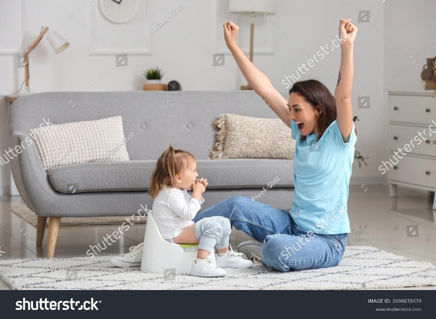 Mother potty training her little daughter at home