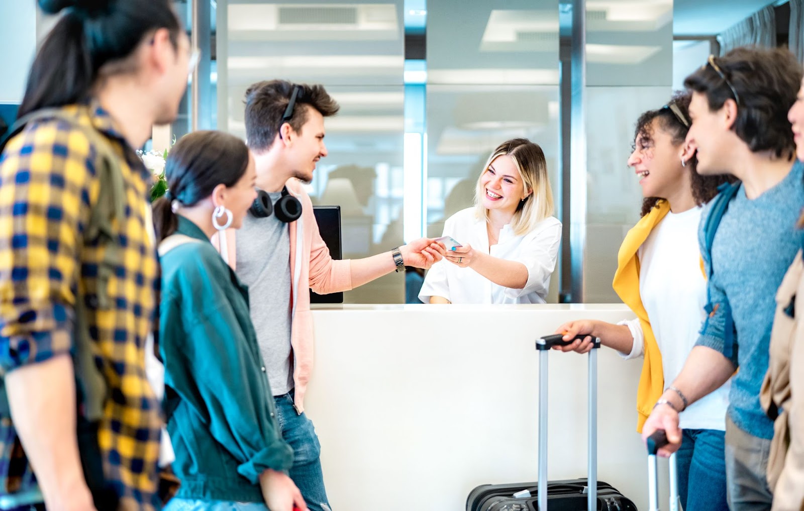 Jovens amigos se divertindo na recepção do hotel na hora do check-in