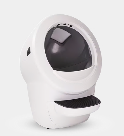 A Ragdoll cat sits beside a Litter-Robot with a calico cat inside, illustrating a dog-proof litter box solution.