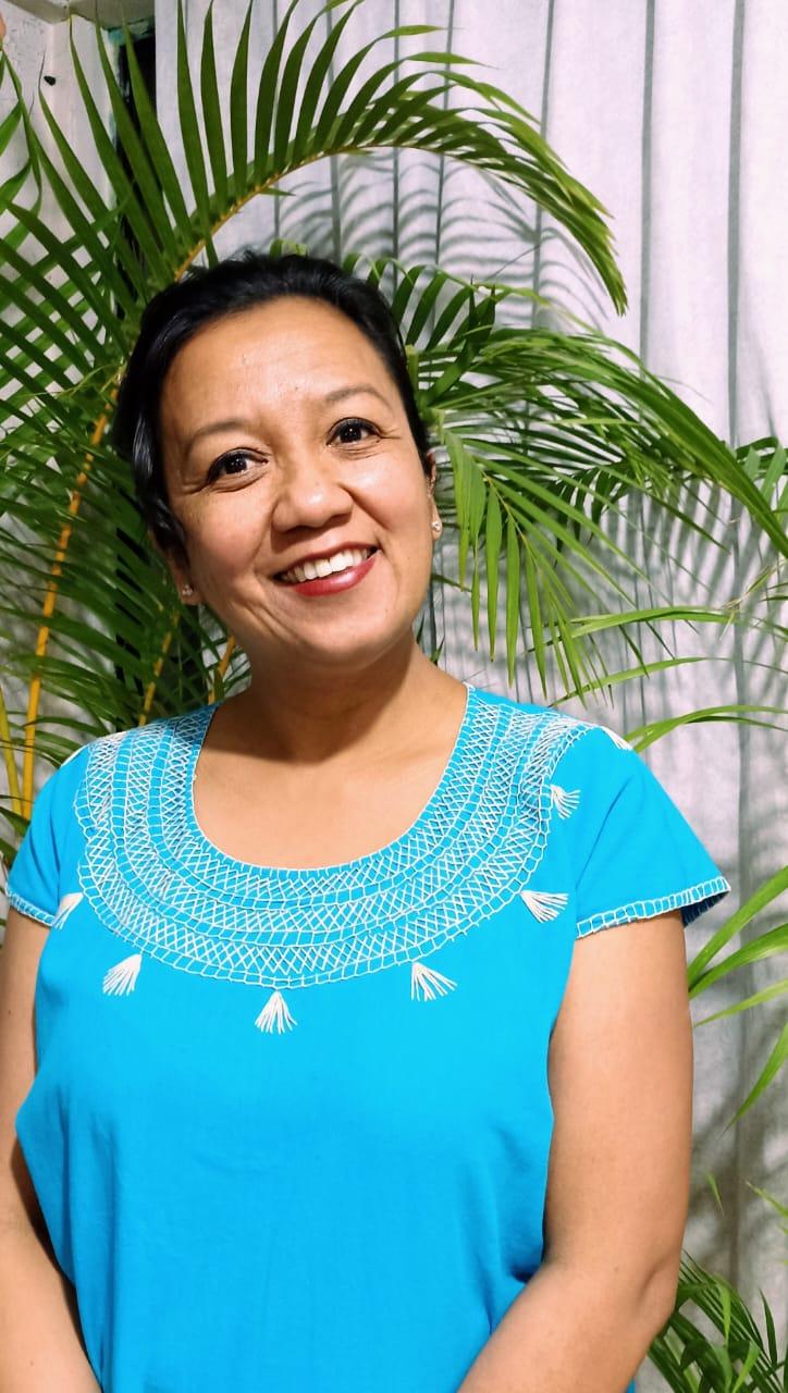 Mujer sonriendo con una camisa azul

Descripción generada automáticamente