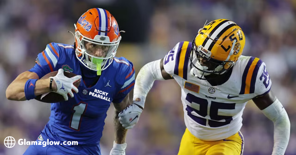 The image depicts a college football game between the Florida Gators and the LSU Tigers. On the left, a Florida Gators player, Ricky Pearsall, wearing a blue uniform with the number 1, is running with the football, holding it securely as he tries to evade a tackle. On the right, an LSU Tigers player wearing a white uniform with the number 25 is attempting to tackle Pearsall. Both players are in action, and the background is slightly blurred, indicating movement and intensity on the field.