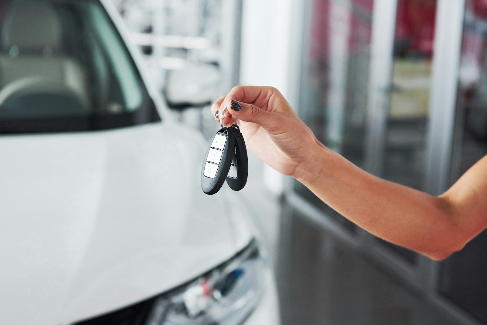 a woman holding the keys to a new car
