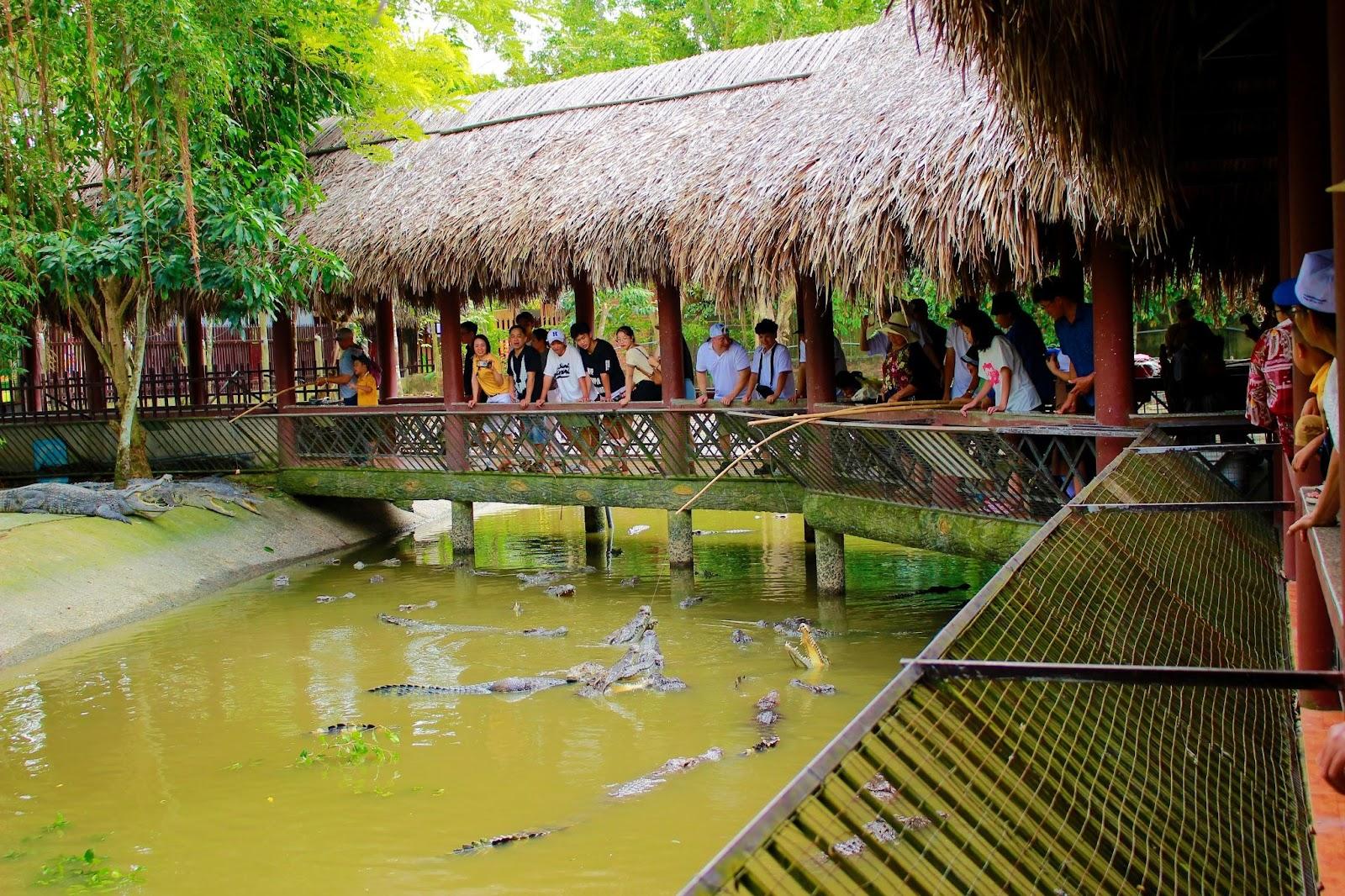 A group of people standing on a bridge over waterDescription automatically generated