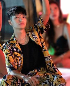 This contain Simon Dominic  sitting on the ground with her hand up in the air and other people behind him