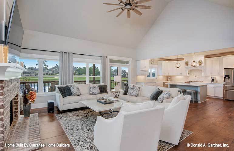 The great room is crowned with a high cathedral ceiling and opens to the kitchen.