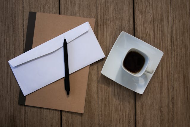a white envelope next to a coffee cup
