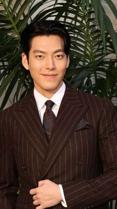 This contains an image of: Kim Woo Bin wearing a brown strip suit 