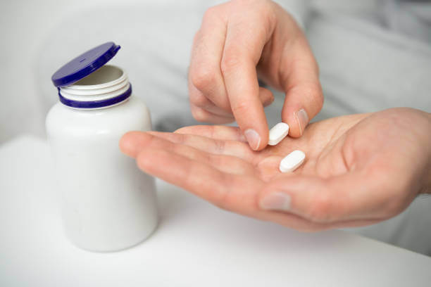 A person holding magnesium capsules in their hand, emphasizing the importance of supplements for brain health and wellness.