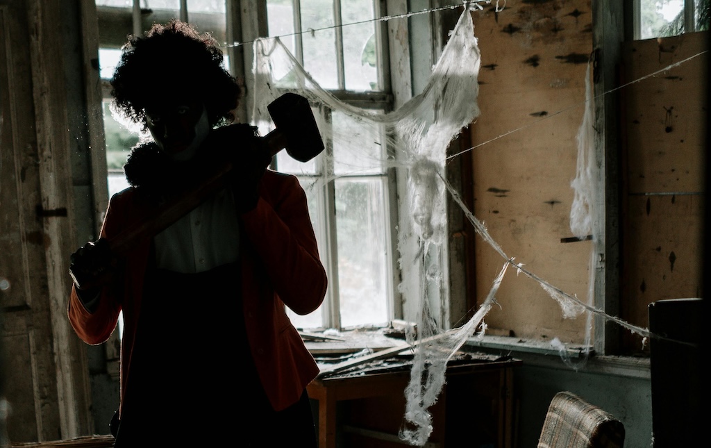 person in clown costume inside abandoned room