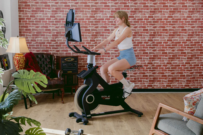 Woman using the SOLE SB1200 Exercise Bike.