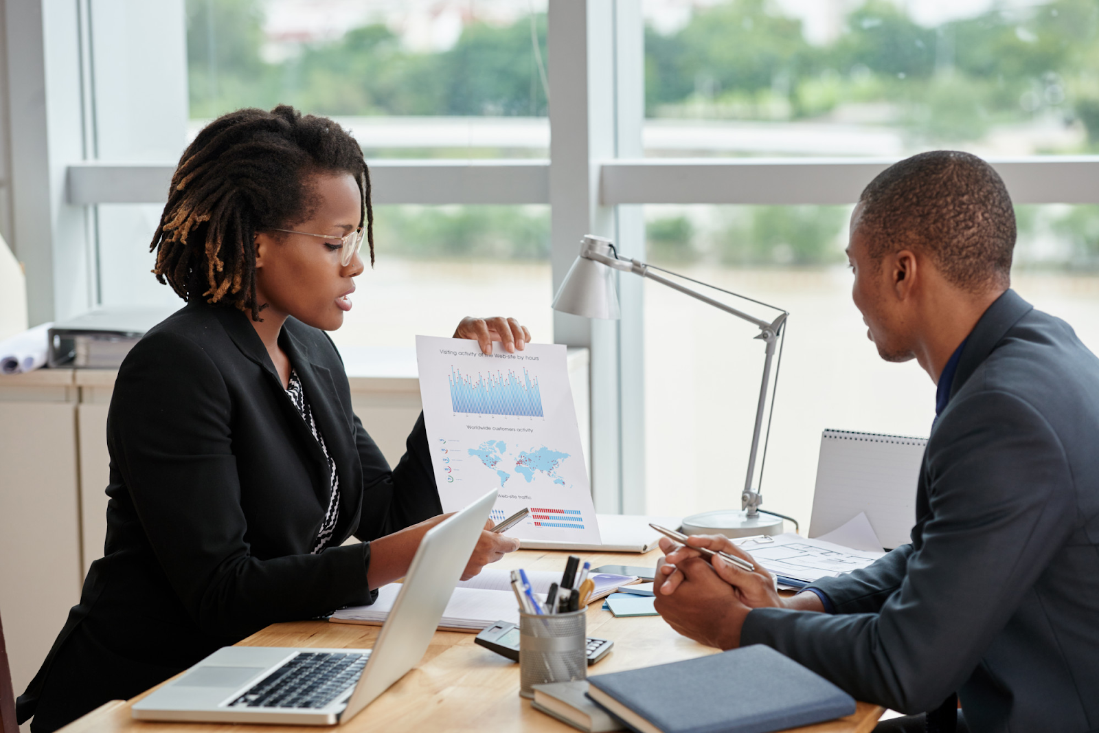 A credit repair specialist showing a chart to her client and explaining to him why he needs credit repair