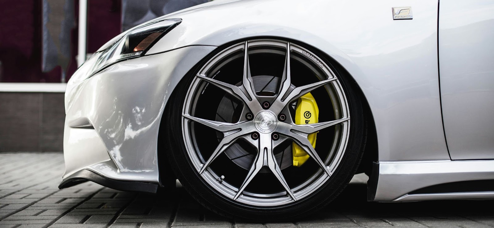  A car fender, highlighting its design and contour over the wheel.