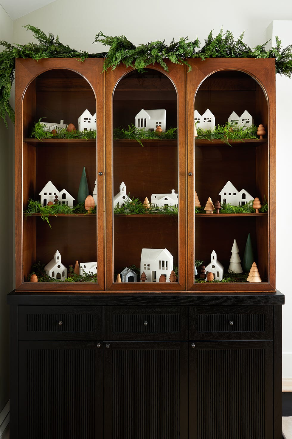 a wooden cabinet with christmas village