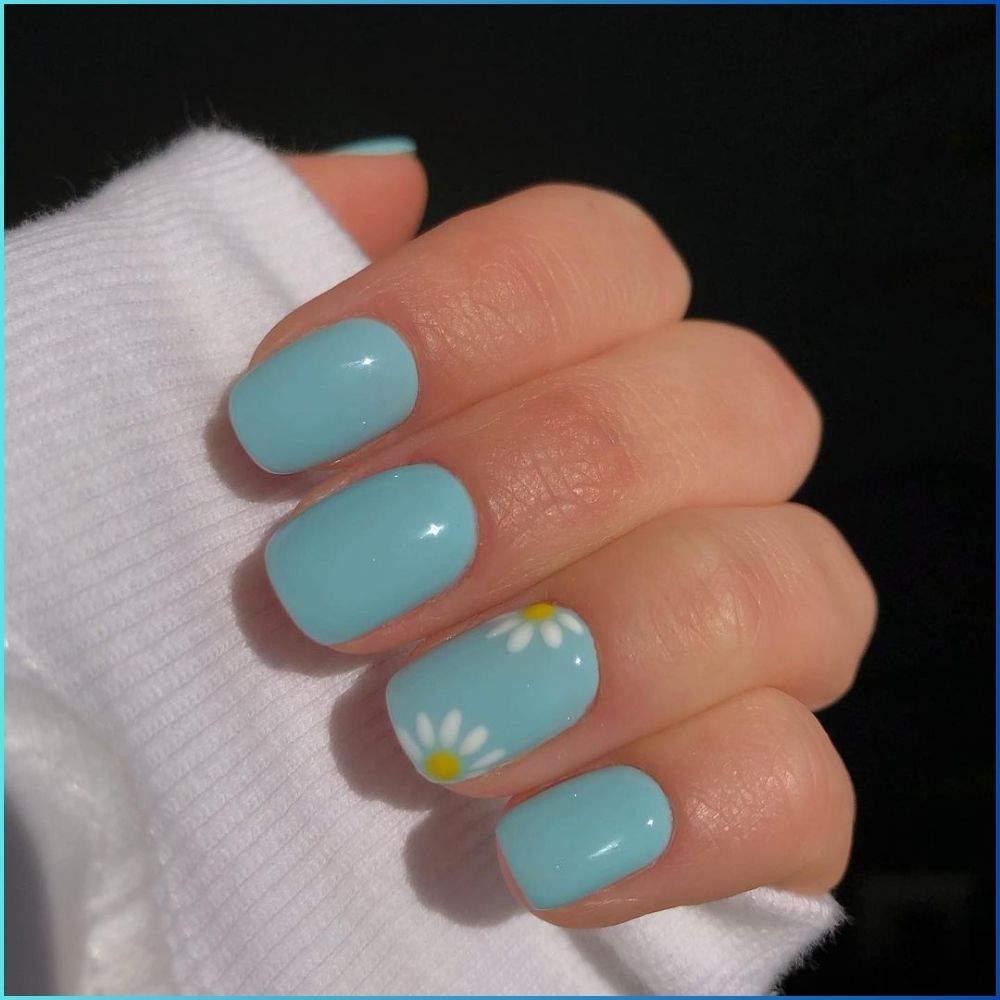 Close up of hands with flowered designed blue nails having Simple Blue Nail Art of sky blue color