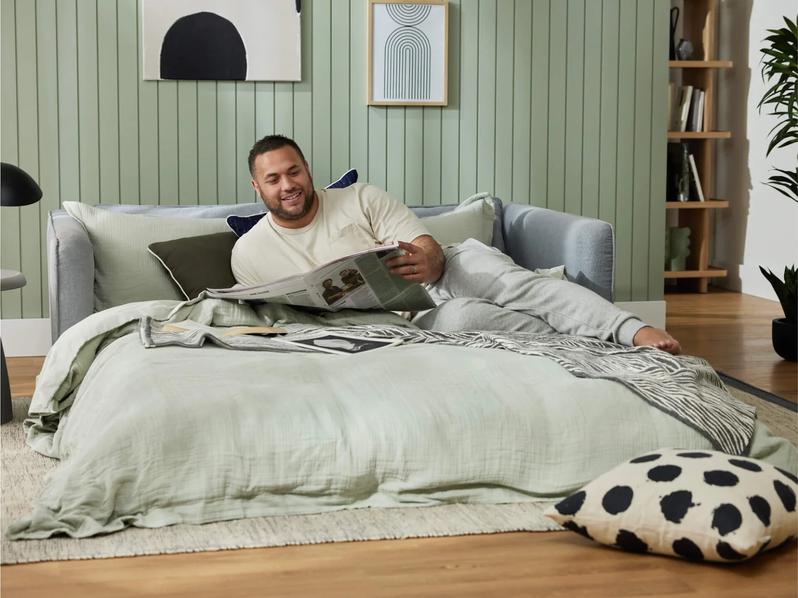 man reading on fold-out sofa