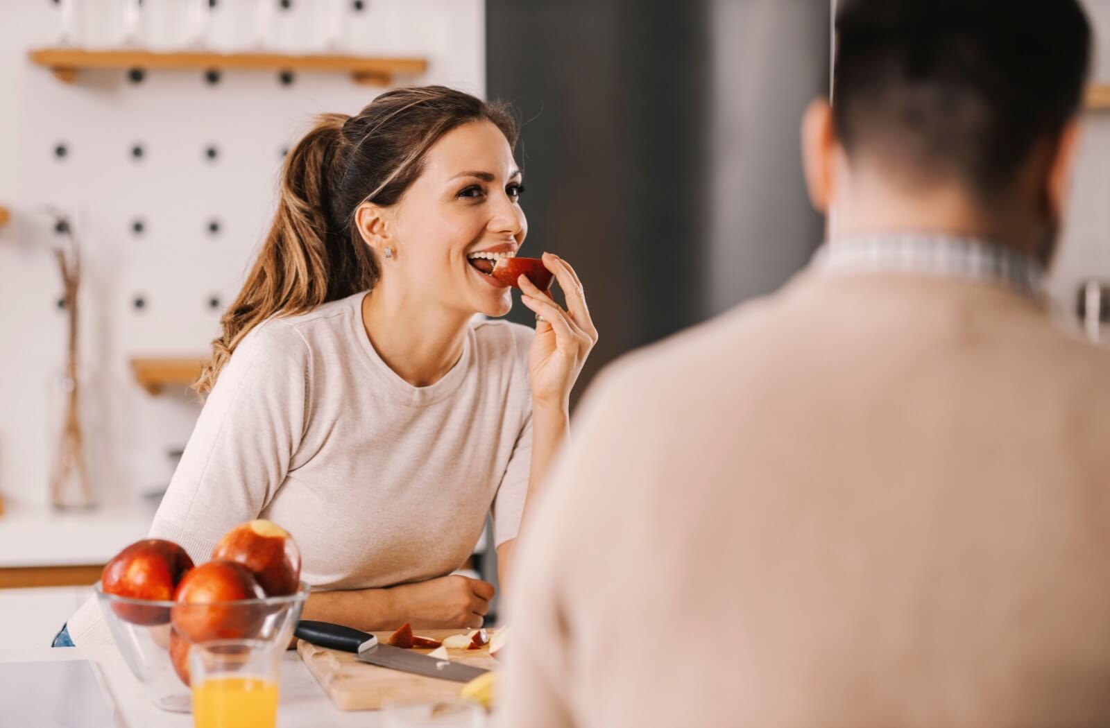 A couple enjoying an apple as a snack to help keep their teeth clean.