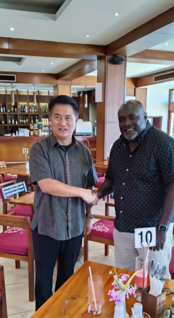 Two men shaking hands in a restaurantDescription automatically generated
