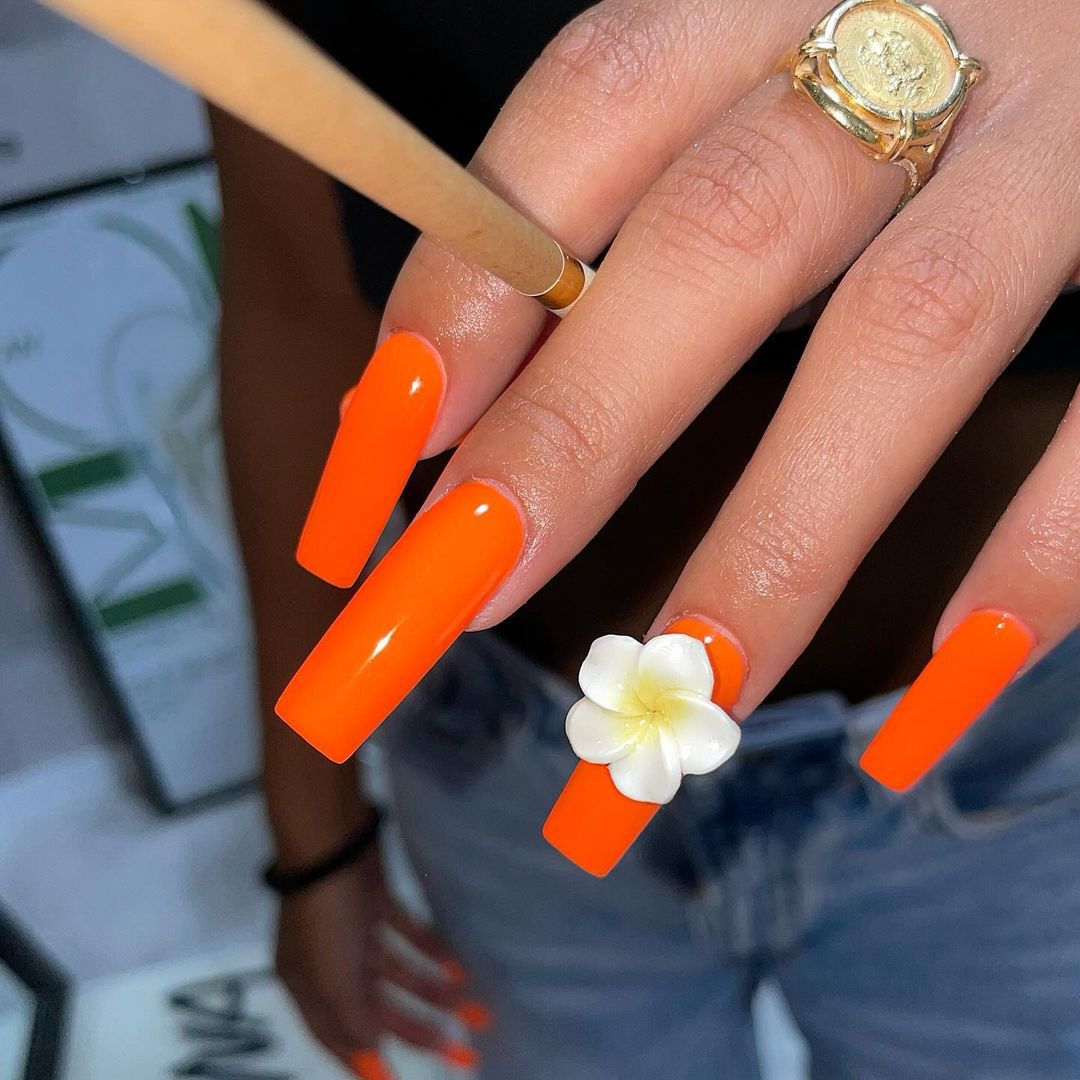 Close up of nails with glittery orange nails having Glossy Orange Dreams