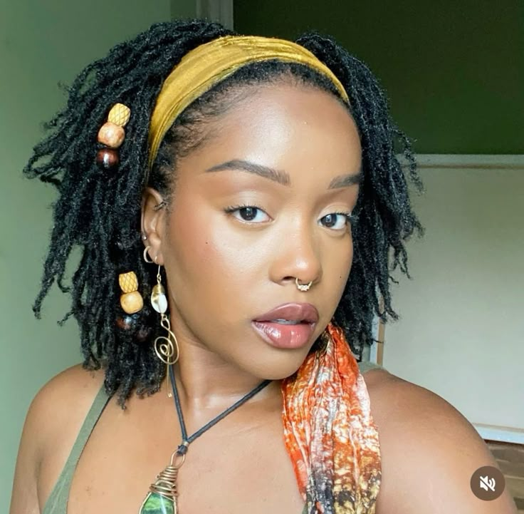 a lady styling her locs with beads