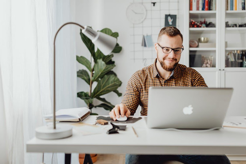 Free Adult male working remotely in a stylish home office with a laptop, displaying a modern workspace. Stock Photo