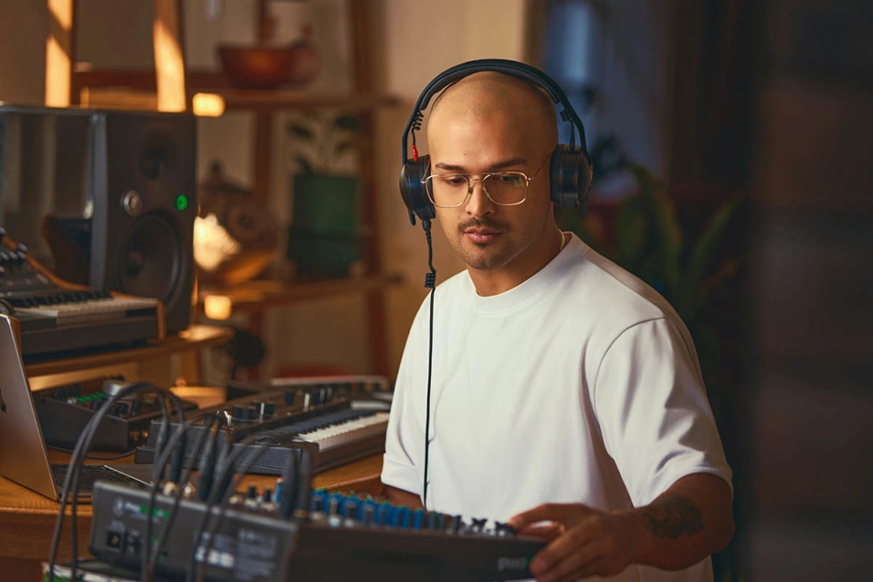 Man wearing RØDE NTH-50 headphones in studio.