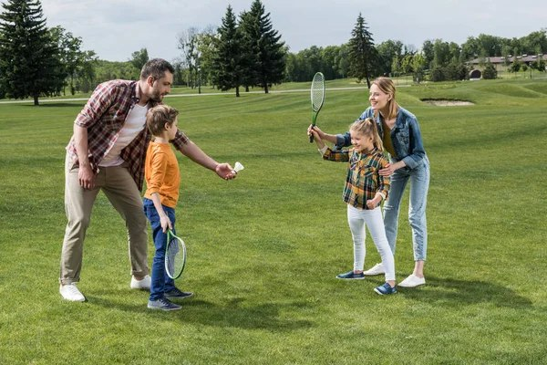 Famille jouant au badminton en extérieur