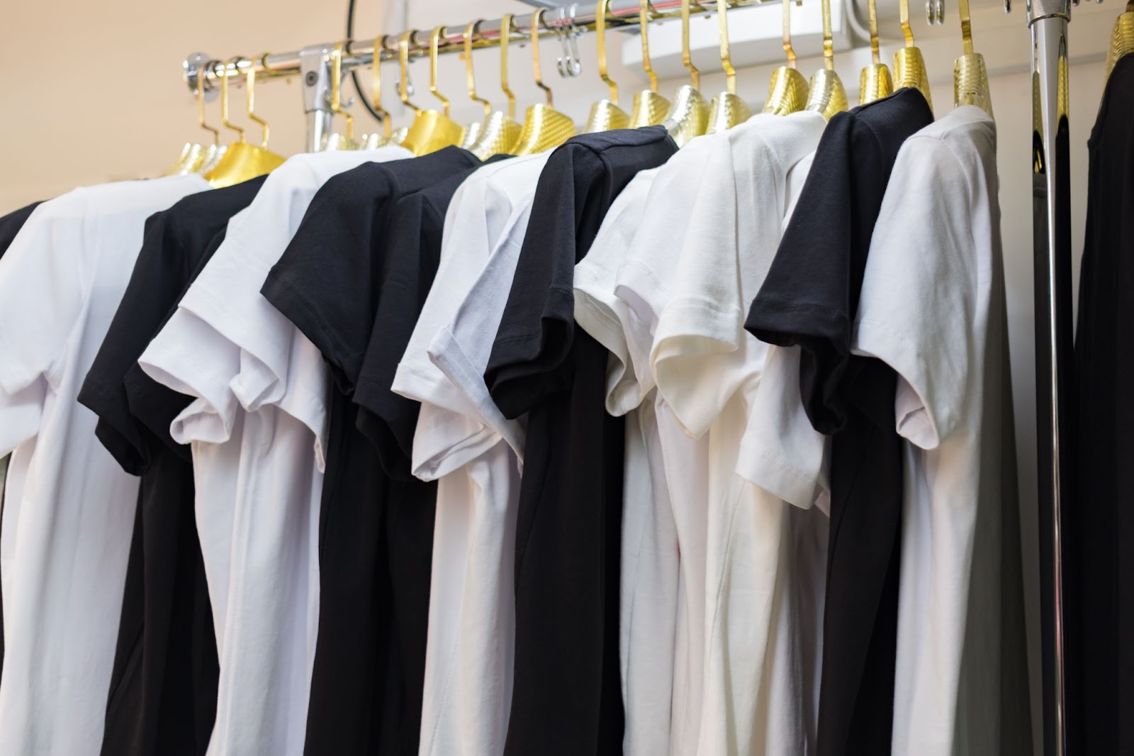 A batch of black and white T-shirts ready for custom printing.
