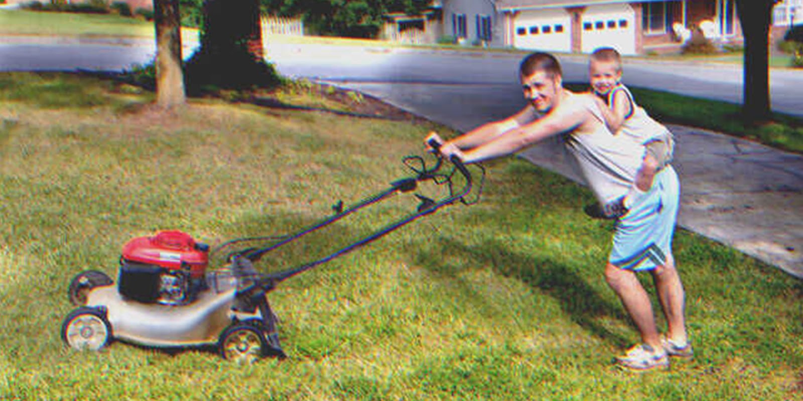 Man mowing lawn with a young boy on his back | Source: Shutterstock