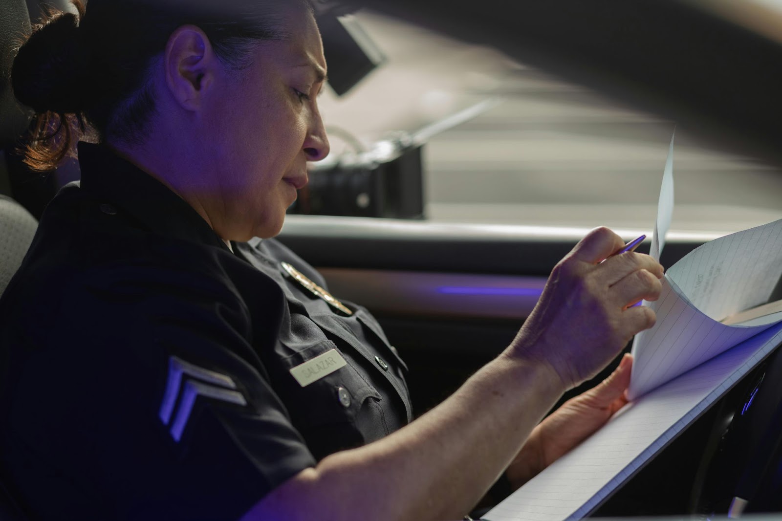 Police officer inside a car examining documents