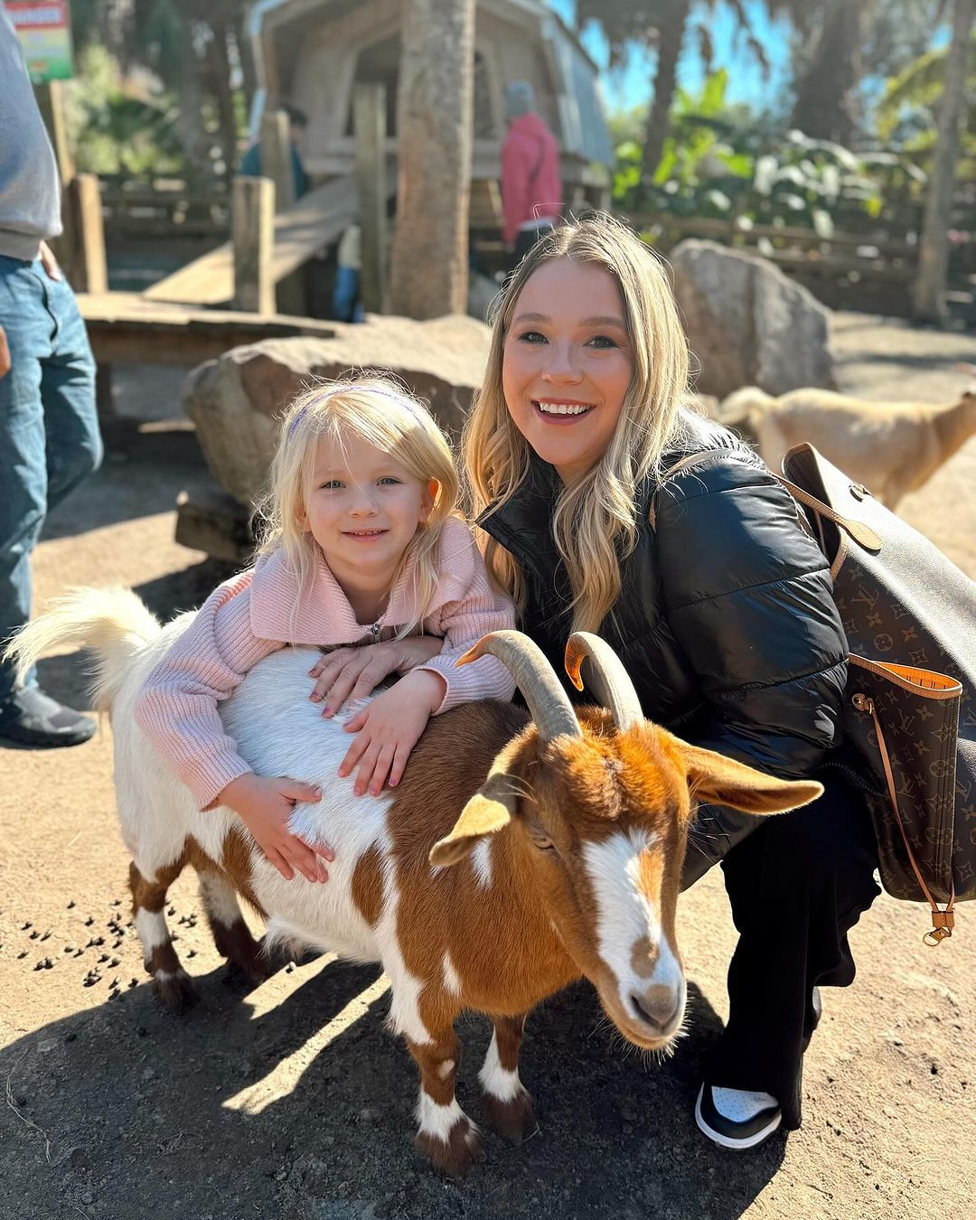 Mother and daughter petting a friendly goat at Wild Florida’s Gator Park petting zoo.
