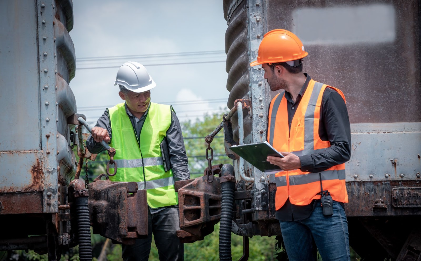 Two male engineers in discussion as they inspect and check the construction process of a railway switch, ensuring precision and safety.