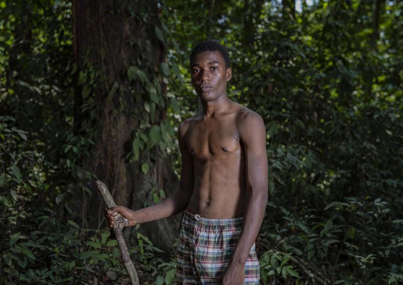 A photo of a young man holding a stick.