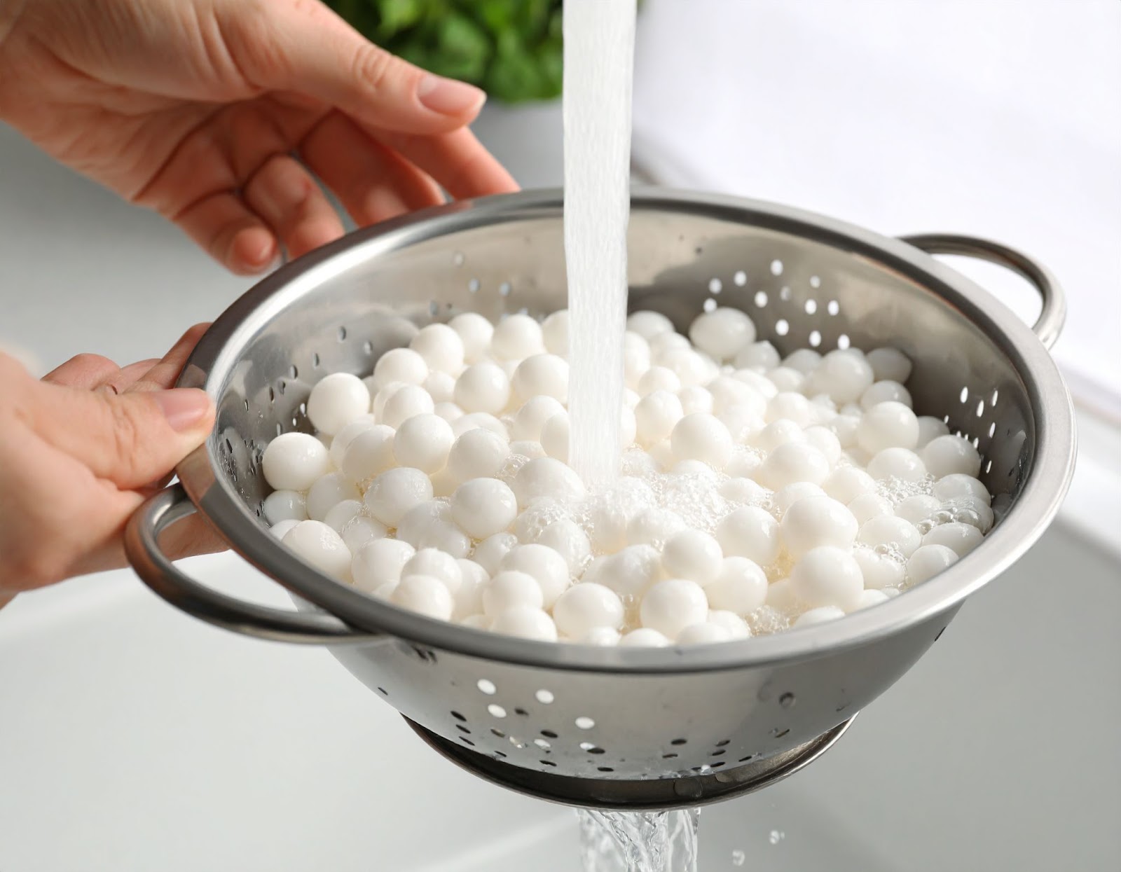 Rinsing cooked tapioca pearls under water