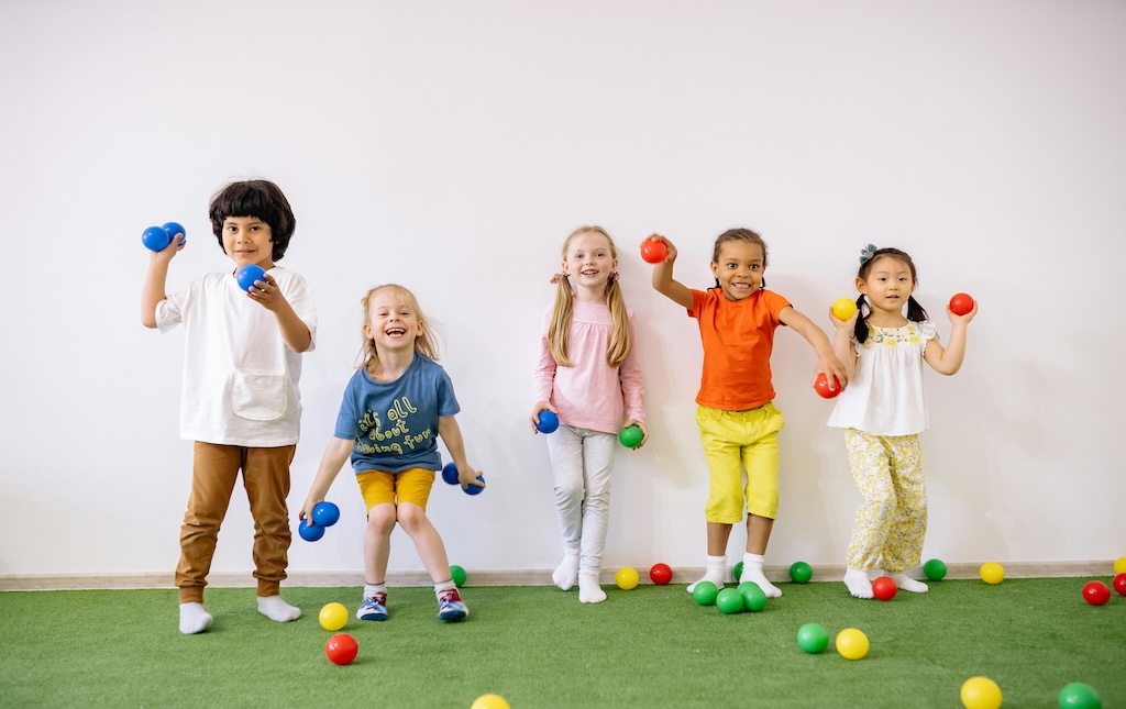 little boys and girls having fun playing with colorful balls