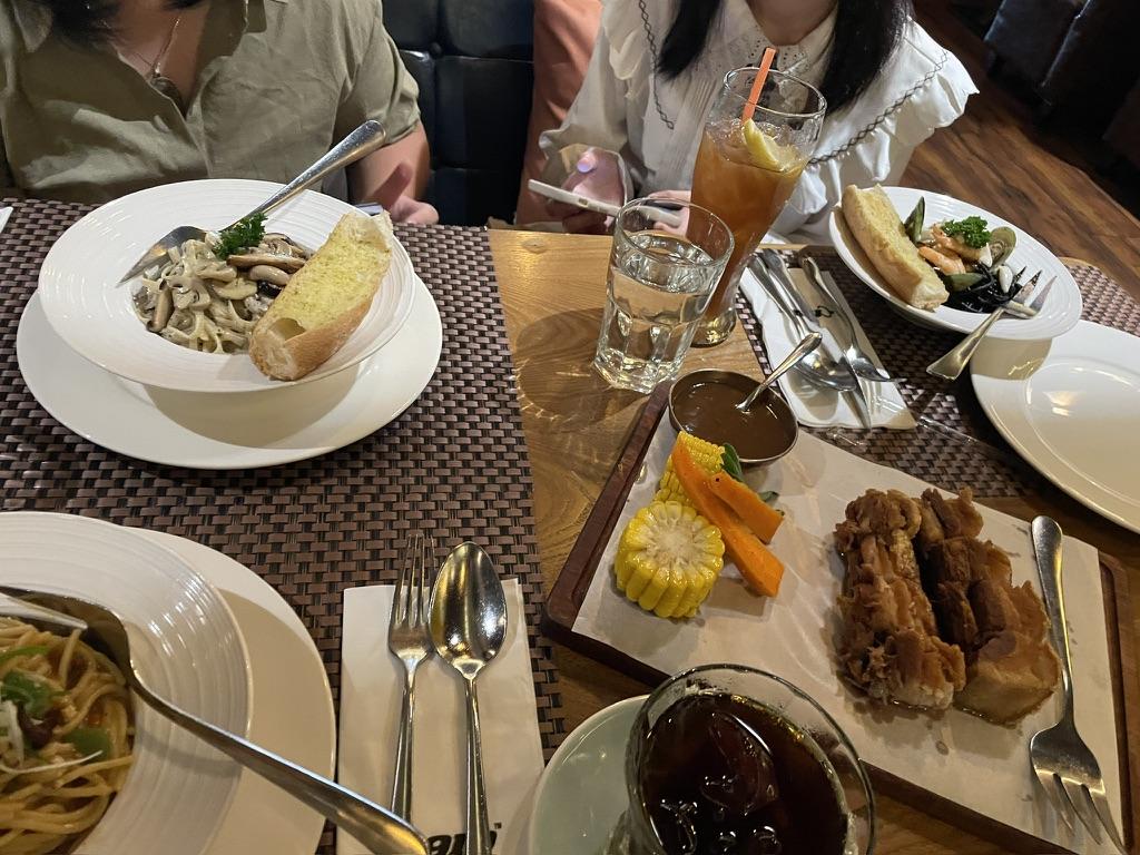 A group of people sitting at a table with plates of food

Description automatically generated