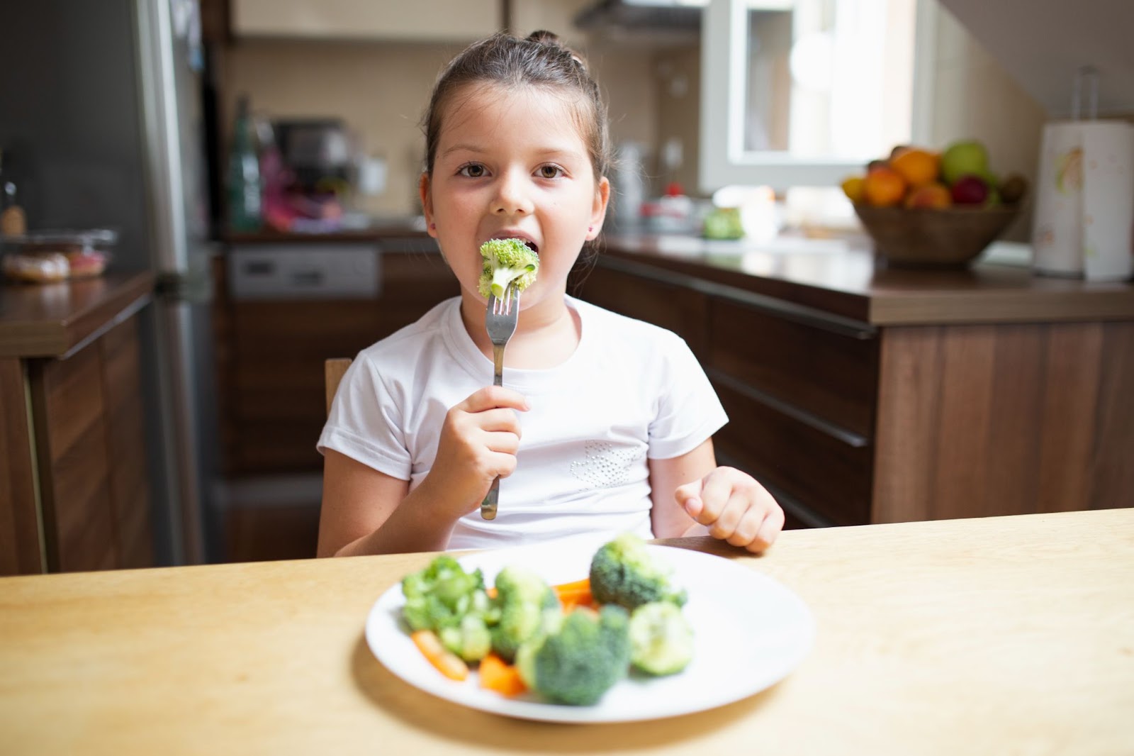 Child enjoying a healthy meal with broccoli and other vegetables