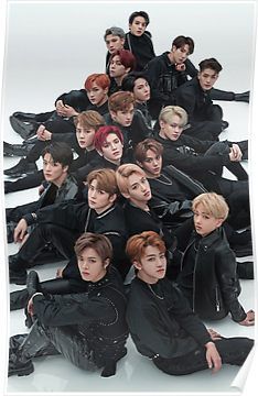 This contains an image of NCT group of young men sitting on the ground with their hands in each other's pockets