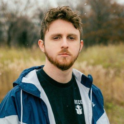 Connor Spence stands in a field looking resolute, while wearing an Amazon Labor Union t-shirt