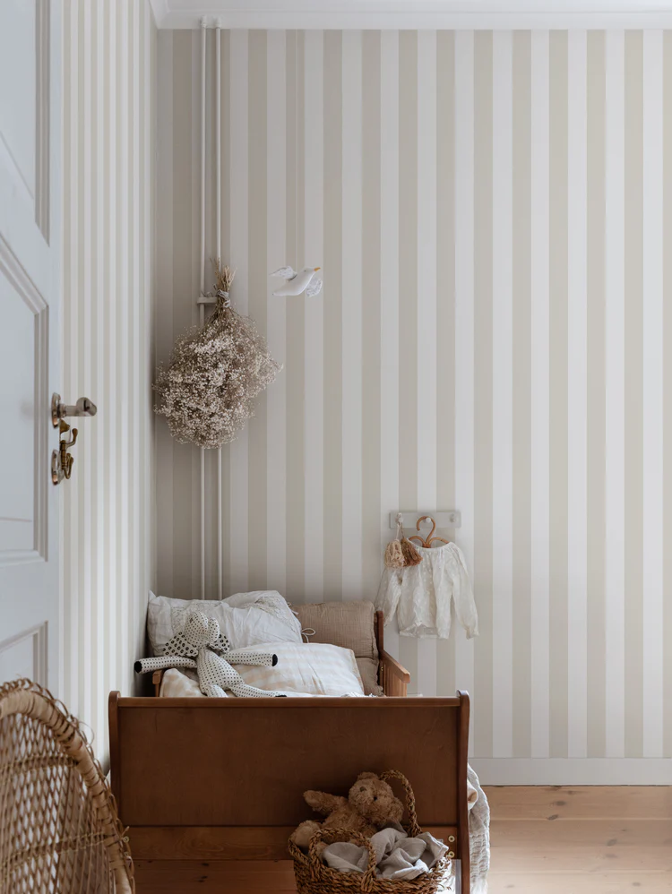 Striped wallpaper in bedroom with dried flowers on the wall