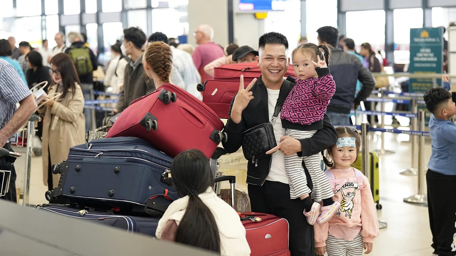 A person holding a child and a group of luggageDescription automatically generated