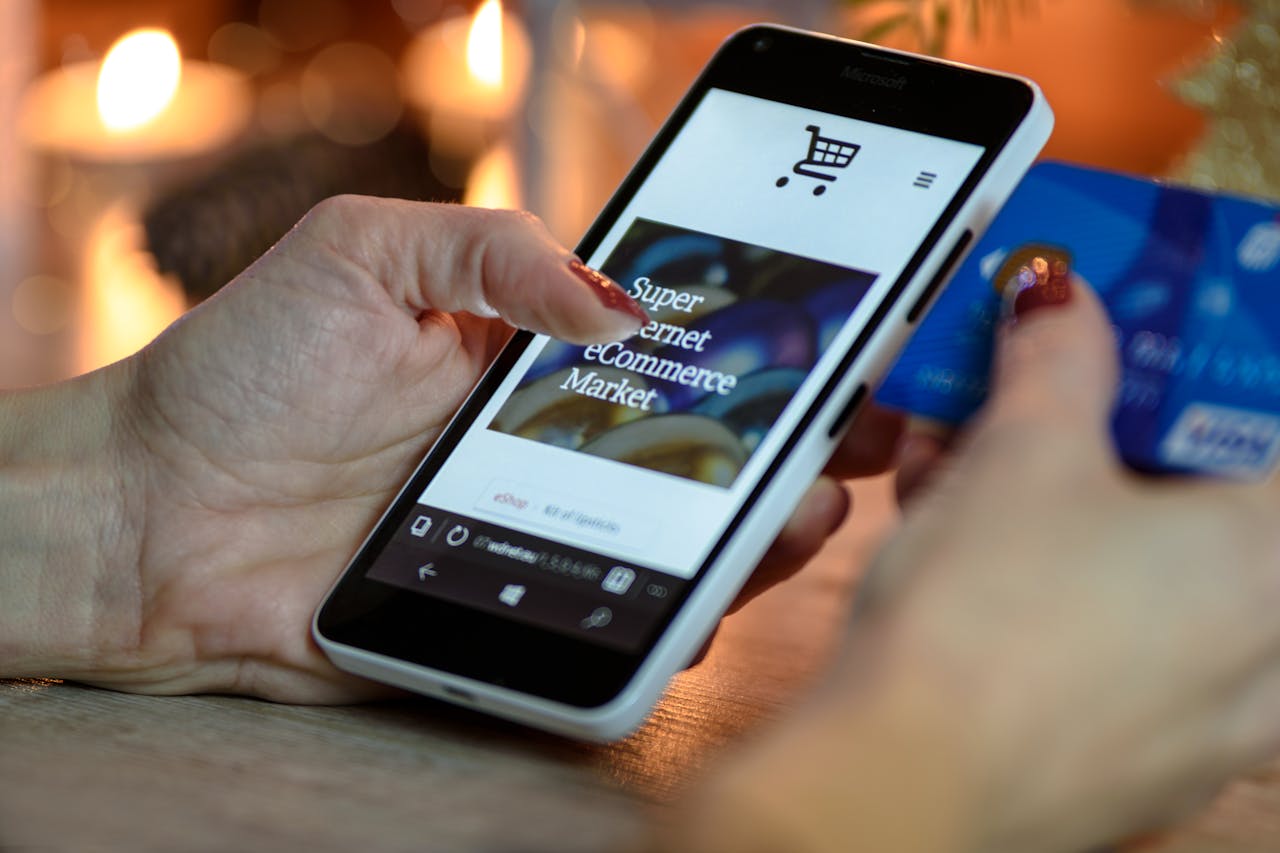 A person shopping online on a smartphone while holding a credit card