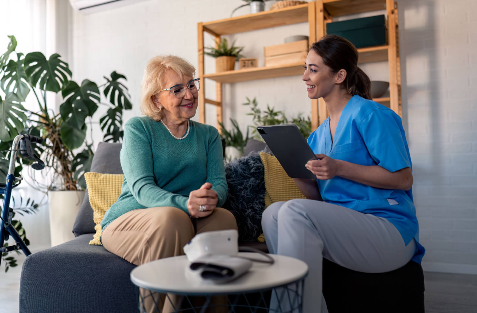 A caregiver in memory care help an older adults take notes on a tablet to build a routine.