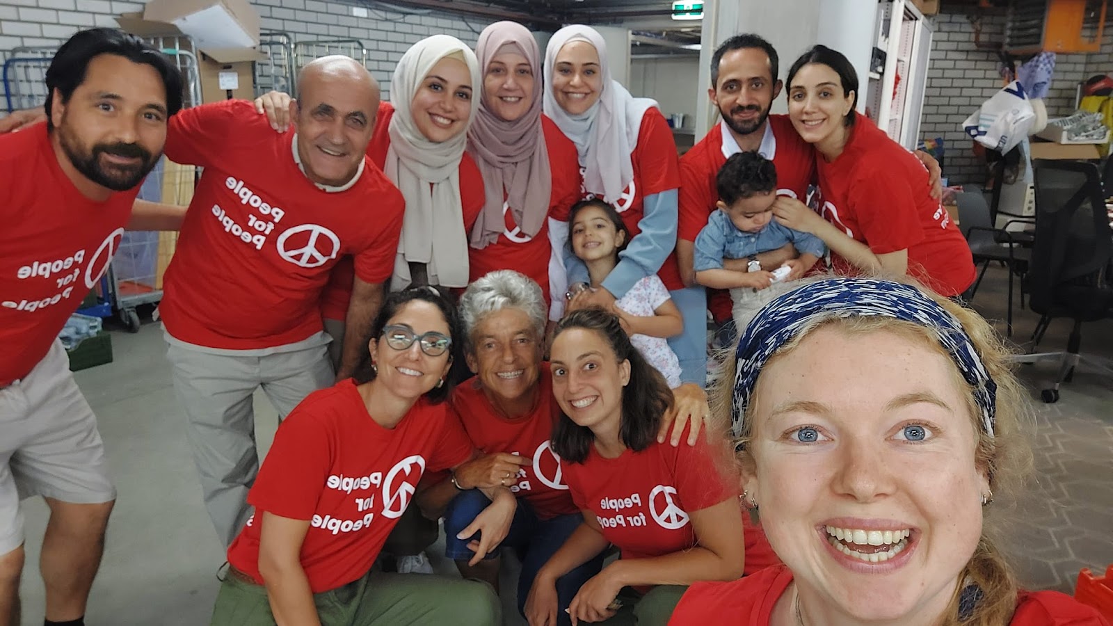 Dania and her family with the People for People team and volunteers in the warehouse.