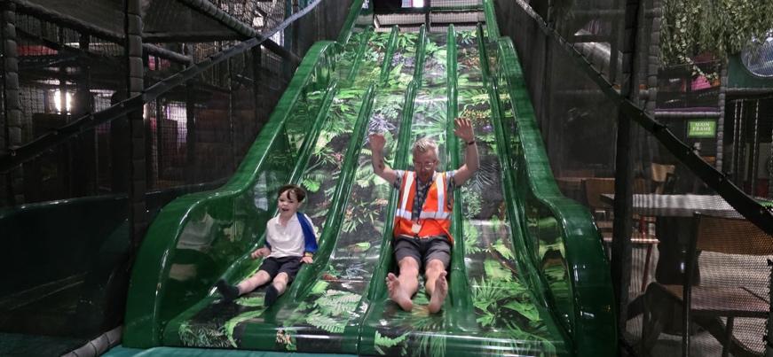 A person and child on a slide

Description automatically generated