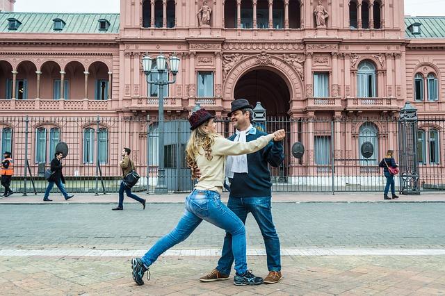 A person and person dancing in front of a pink building

AI-generated content may be incorrect.